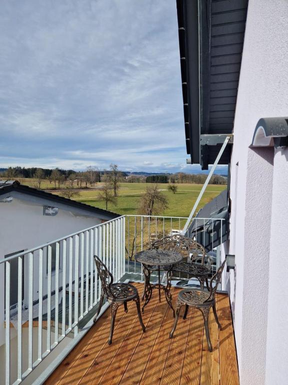 a balcony with two tables and chairs on a deck at Ferienwohnung Amo in Wangen im Allgäu
