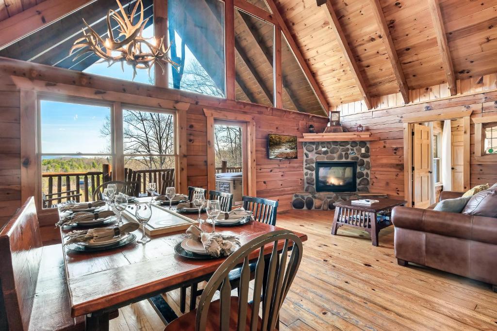 Un comedor con mesa y chimenea. en Alpine Splendor Family Game Room Views Hot Tub, en Sevierville