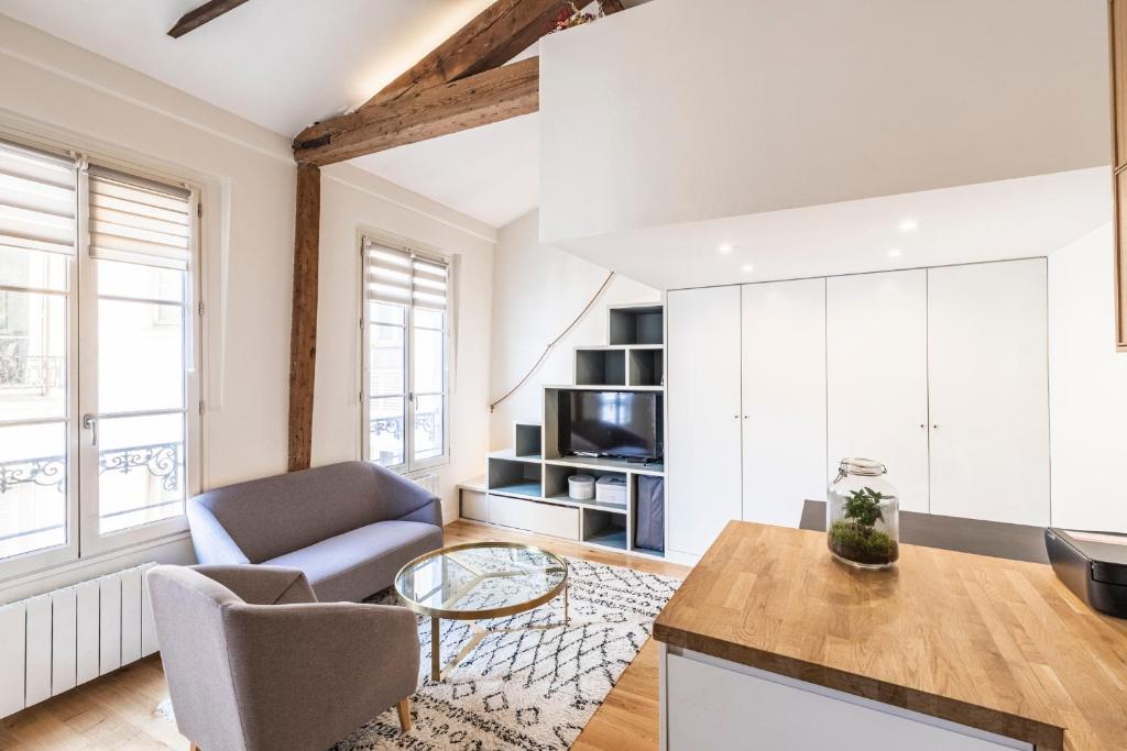 een woonkamer met een bank en een tafel bij Tourville - Très beau studio - Bail mobilité in Parijs