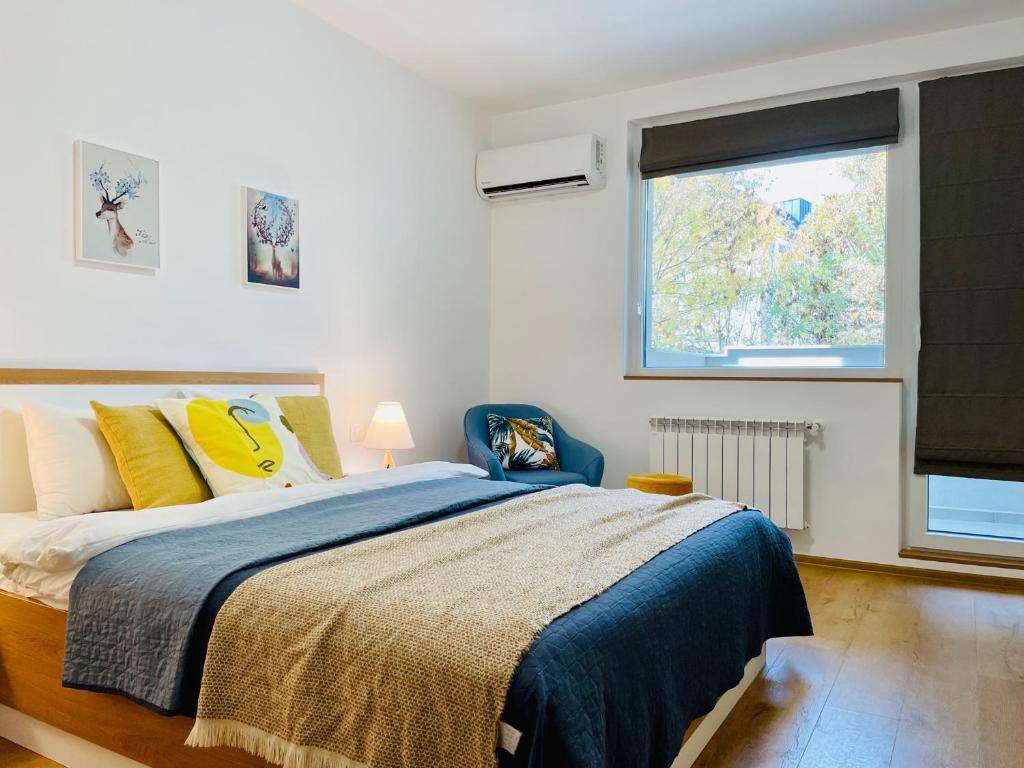 a bedroom with a large bed and a window at Gardenia Apartments in Sofia