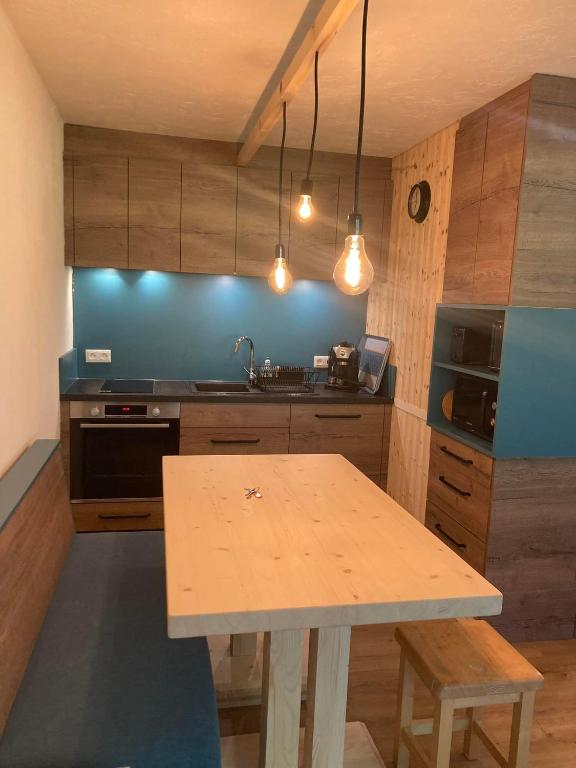 - une cuisine avec une table en bois et un évier dans l&#39;établissement Le cocon du Bettex 1400 - Cozy Apt near Mont Blanc, à Saint-Gervais-les-Bains