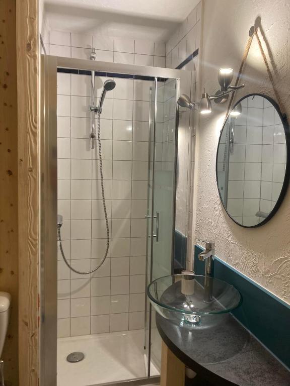 La salle de bains est pourvue d&#39;un lavabo en verre et d&#39;une douche. dans l&#39;établissement Le cocon du Bettex 1400 - Cozy Apt near Mont Blanc, à Saint-Gervais-les-Bains