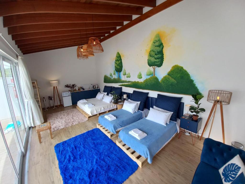 a living room with blue couches and a painting on the wall at Casa francesa de Piraju in Piraju