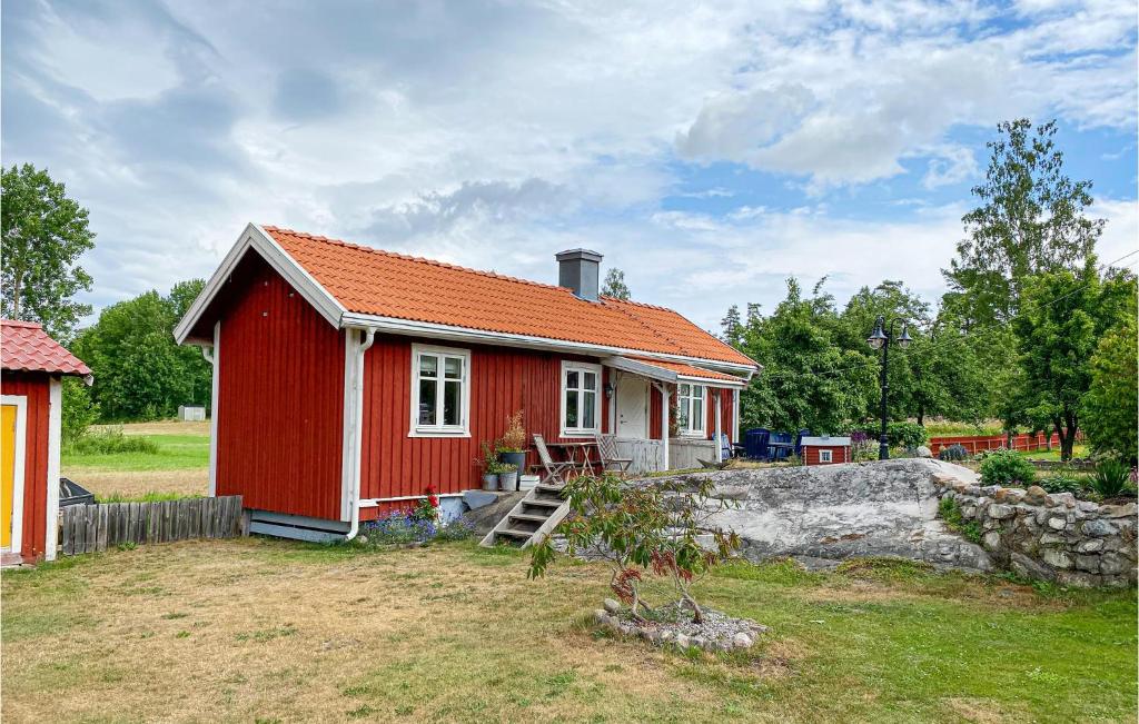een rood huis met een oranje dak in een tuin bij Beautiful Home In Vstervik With Wifi in Västervik