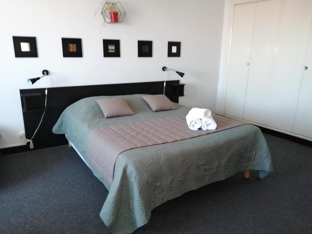 1 dormitorio con 1 cama con 2 toallas en Hotel la coursive, en La Cotinière