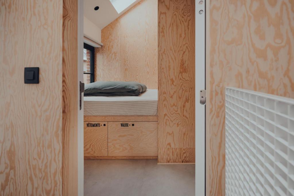 ein kleines Schlafzimmer mit einem Bett in einem kleinen Zimmer in der Unterkunft Cabane Urbaine 3 - centre in Namur