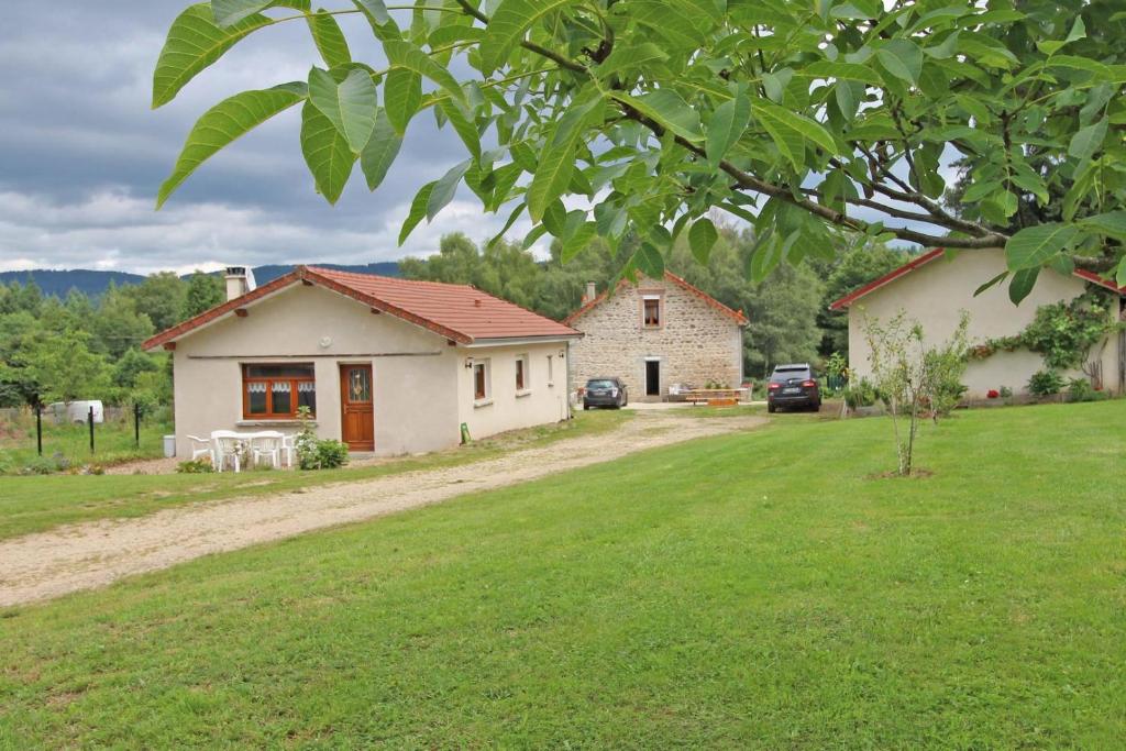 a house with a green lawn in front of it at Au bon accueil in Peyrat-le-Château