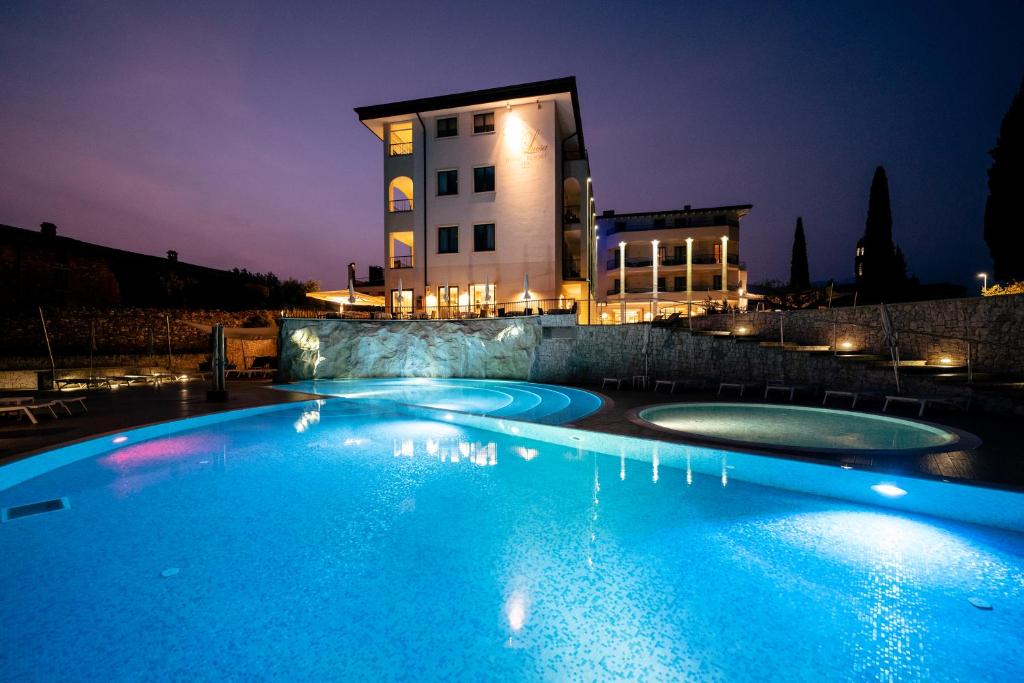 a swimming pool in front of a building at night at Hotel Resort Villa Luisa & Spa in San Felice del Benaco