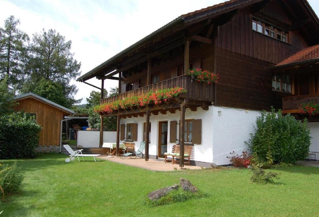 una casa con un balcón con flores. en Ferienwohnungen Haus Reineck, en Bayerisch Eisenstein