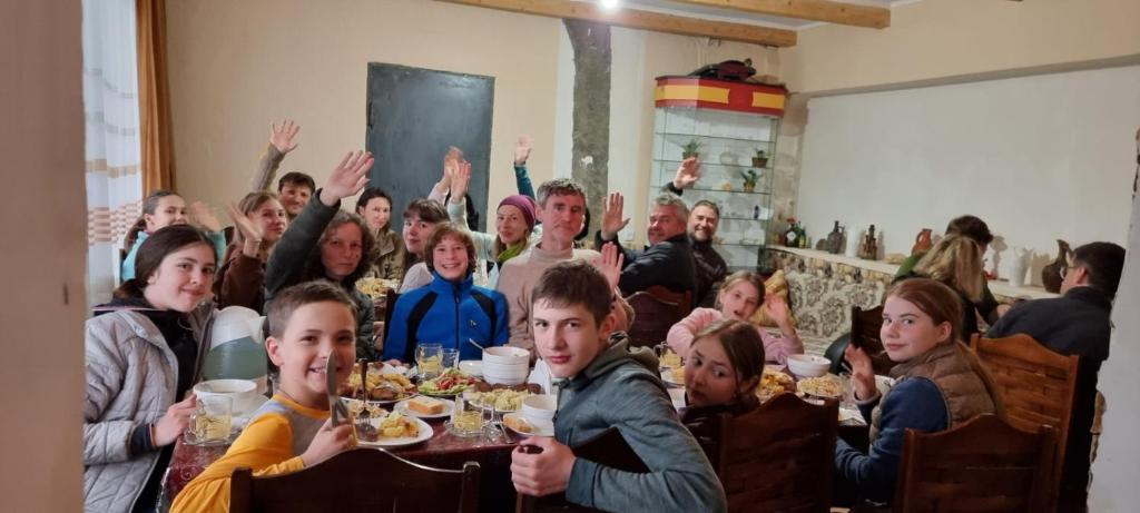 Eine Gruppe von Menschen, die an einem Tisch sitzen und Essen essen. in der Unterkunft Betegi Guest House in Mestia