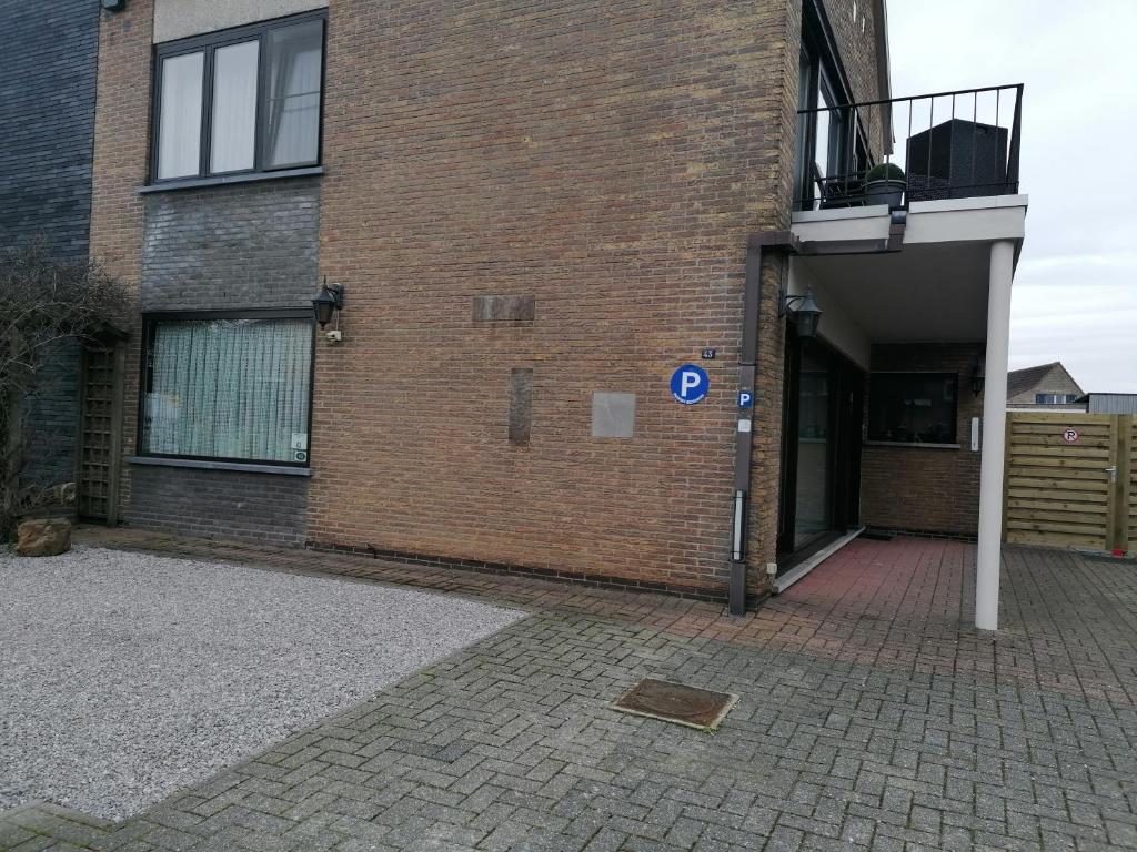 a brick building with a parking sign in front of it at Logies Lily in Oudenburg