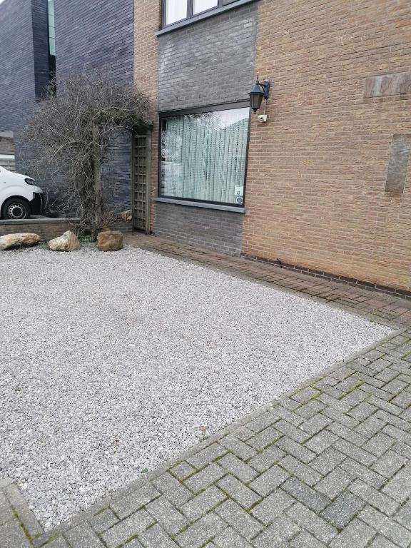 a parking lot in front of a brick building at Logies Lily in Oudenburg