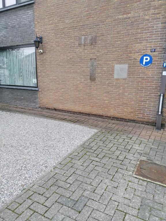 a brick building with a parking sign on it at Logies Lily in Oudenburg