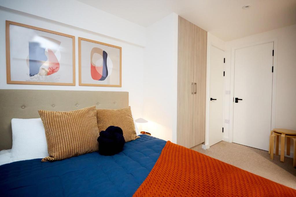 a bedroom with a blue bed with two pillows at Luxury new built split-level flat with rooftop gardens access in Manchester