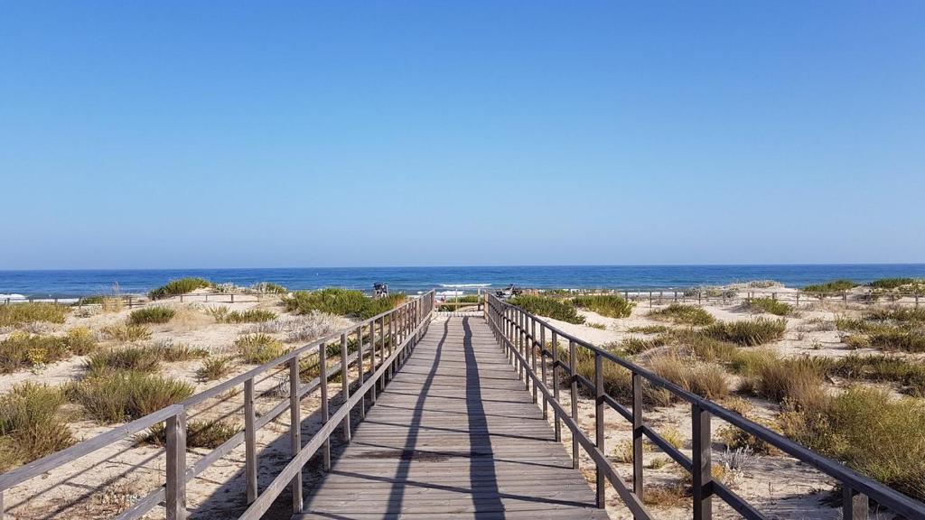 a wooden boardwalk leading to the beach at Apartamento Praia de Altura in Altura
