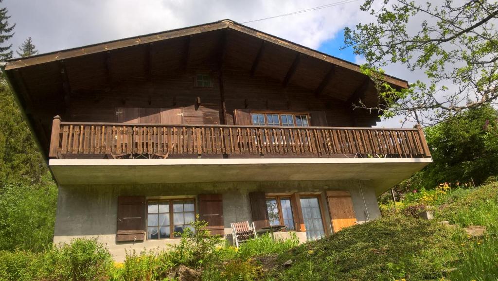 a house with a balcony on top of a hill at Ferienwohnung Bischoff in Schwarzsee