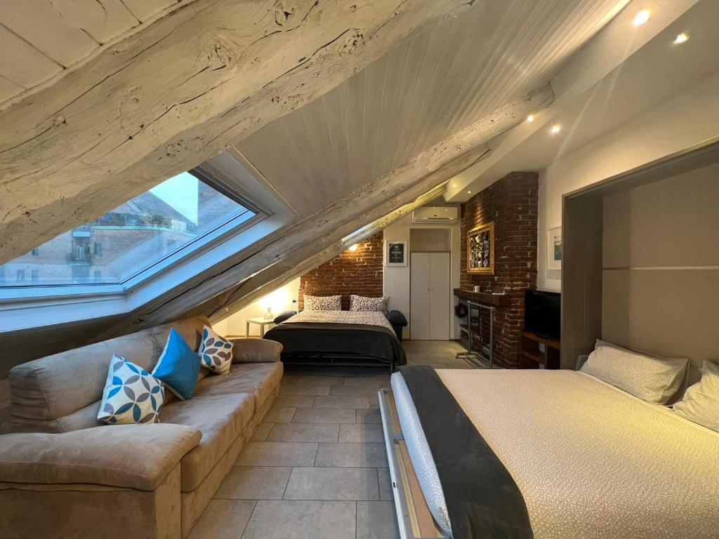 a attic bedroom with two beds and a couch at ACADAMIS - Loft dei Principini in Turin