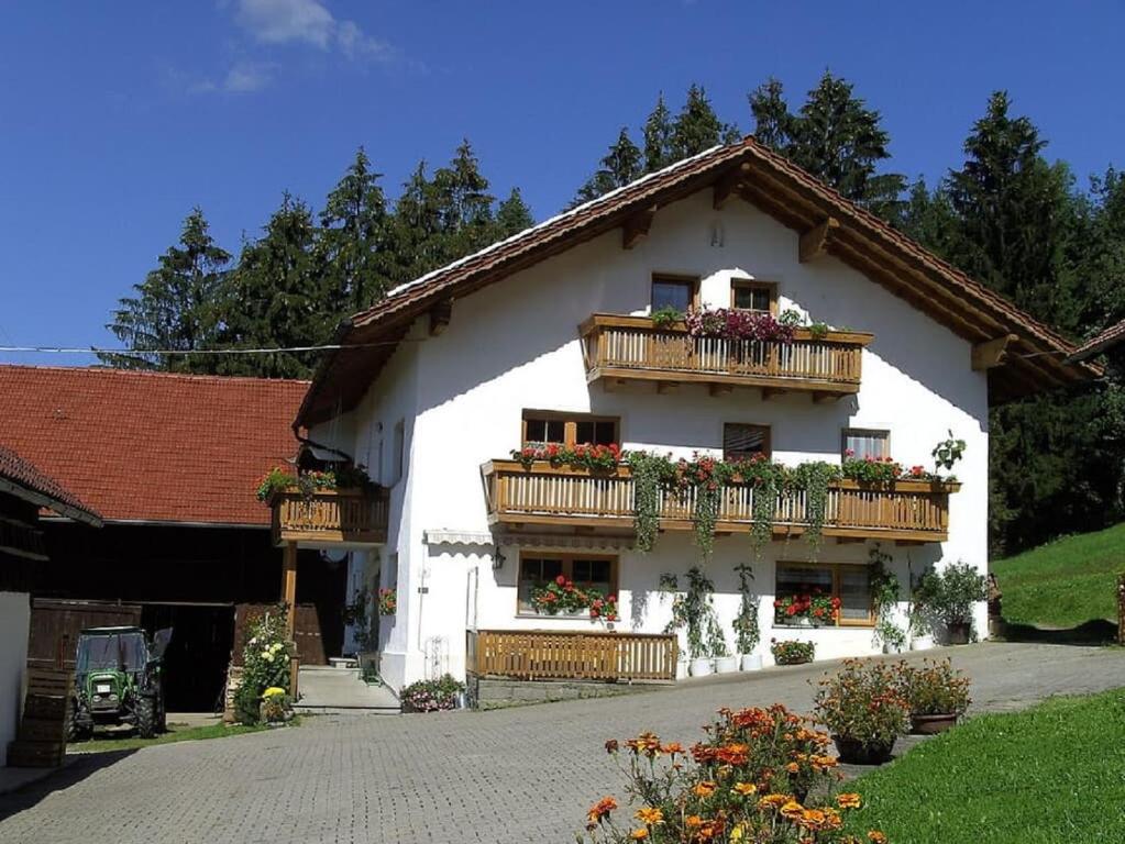 ein weißes Gebäude mit Balkonen und Blumen darauf in der Unterkunft Ferienhof Fernblick in Lalling