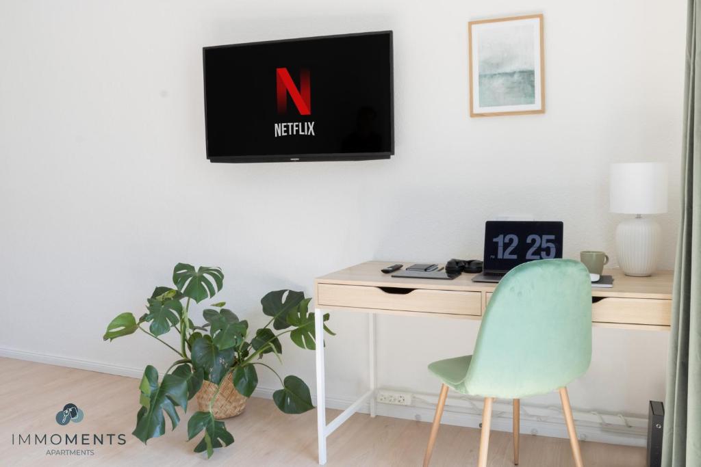 escritorio con silla y monitor en la pared en Stilvolles Apartment im Zentrum mit Netflix WE23 en Magdeburgo