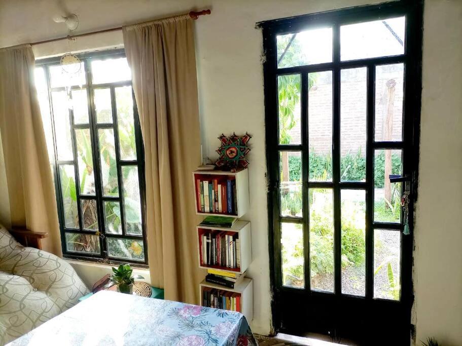 um quarto com duas janelas grandes e uma estante de livros em Relajante y amplio con jardín em Presidencia Roque Sáenz Peña