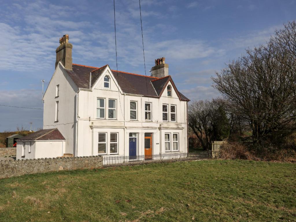 a white house with a black roof at Gwynant - Morfa Nefyn in Pwllheli