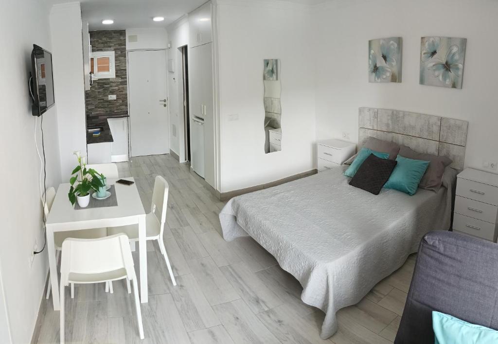 ベナルマデナにあるPRECIOSO APARTAMENTO RESIDENCIAL PISCINA JARDINESのベッドルーム1室(ベッド1台、テーブル、デスク付)