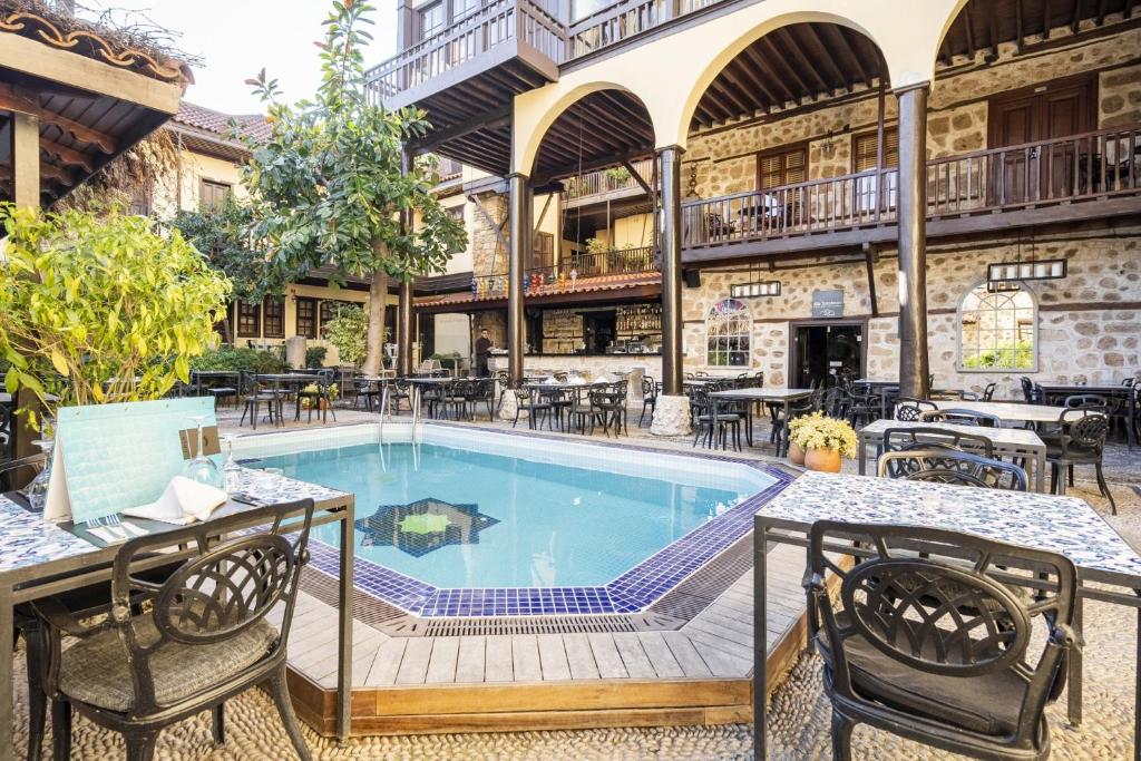 an outdoor patio with a swimming pool and tables and chairs at Lovely Studio Flat near Hadrians Gate in Antalya
