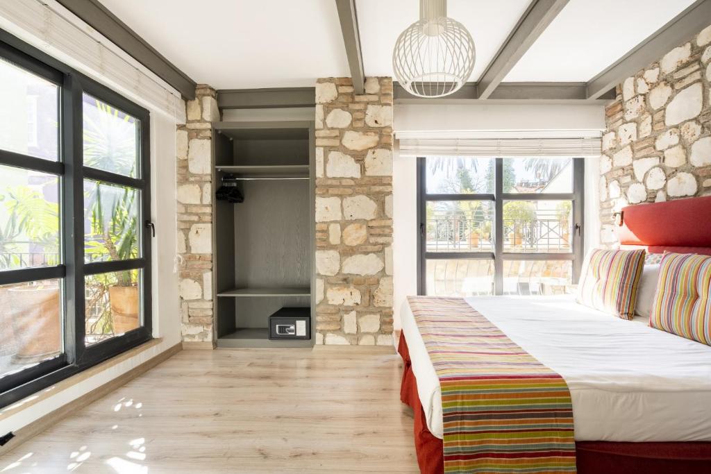 a bedroom with a bed and large windows at Pleasant Flat near Hadrians Gate in Antalya