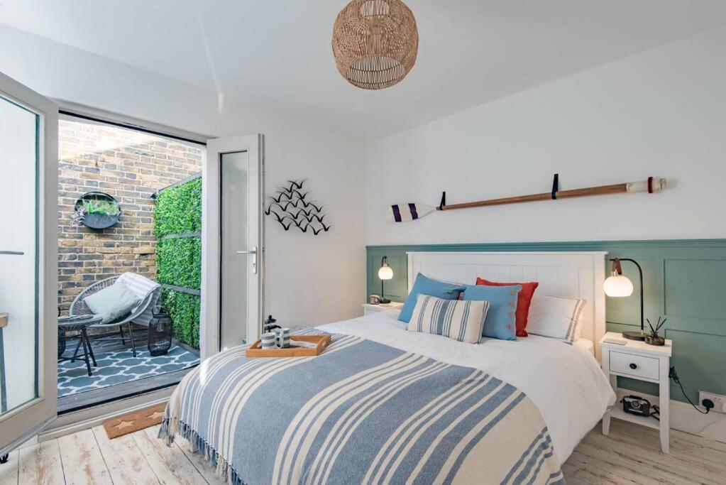sypialnia z dużym łóżkiem i balkonem w obiekcie Seabreeze Cottage w mieście Walmer
