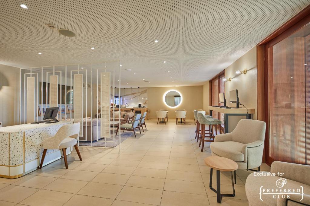 a waiting room with tables and chairs in a hospital at Secrets Lanzarote Resort & Spa - Adults Only (+18) in Puerto Calero