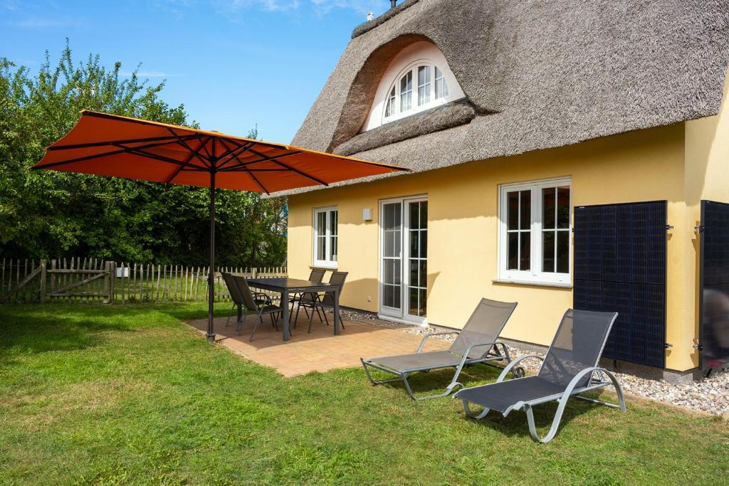 a patio with a table and chairs and an umbrella at CLASSIC Ferienhaus Schwan A10 - a59772 in Gramkow