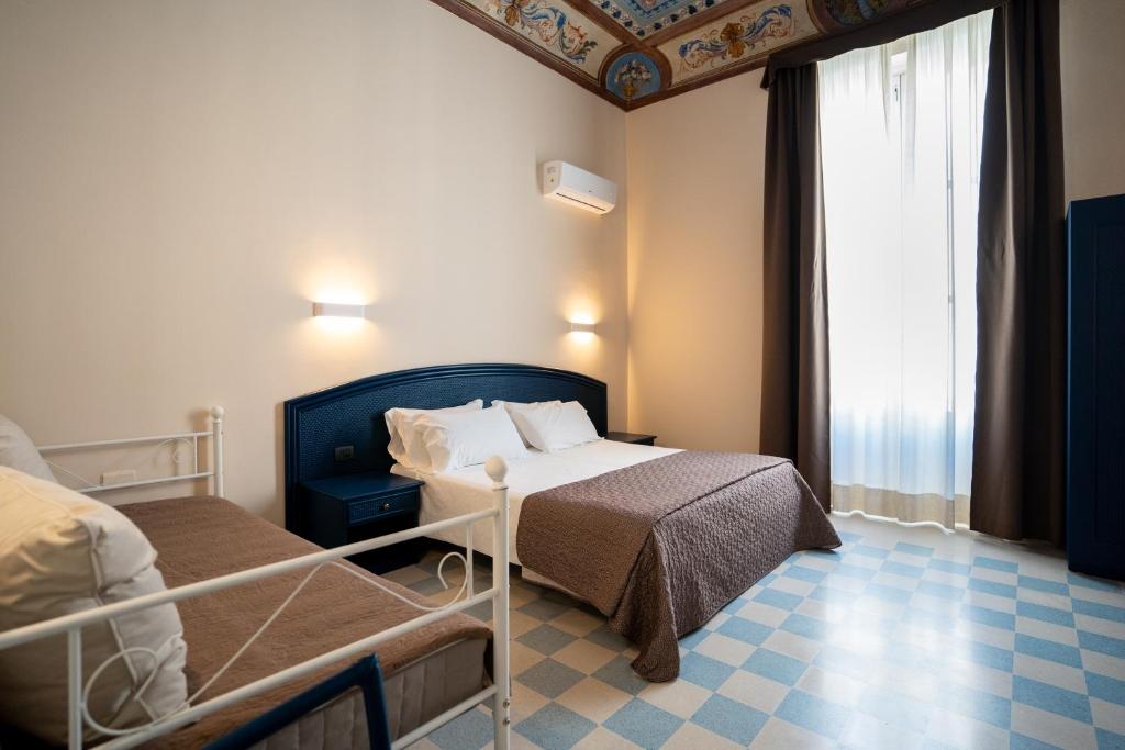 a hotel room with two beds and a window at Gran Bretagna Boutique Hotel Ortigia in Siracusa