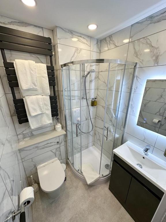 a bathroom with a shower and a toilet and a sink at The Pines Hotel in Swanage