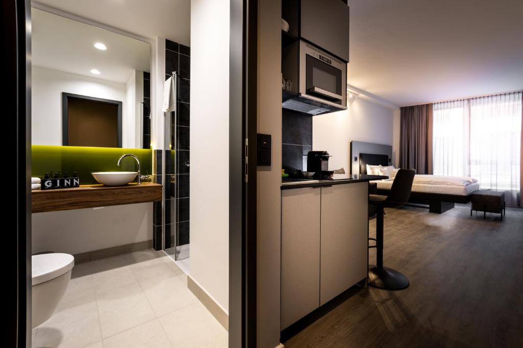 a bathroom with a sink and a toilet in a room at GINN Apartment-Hotel Stuttgart-Esslingen in Esslingen