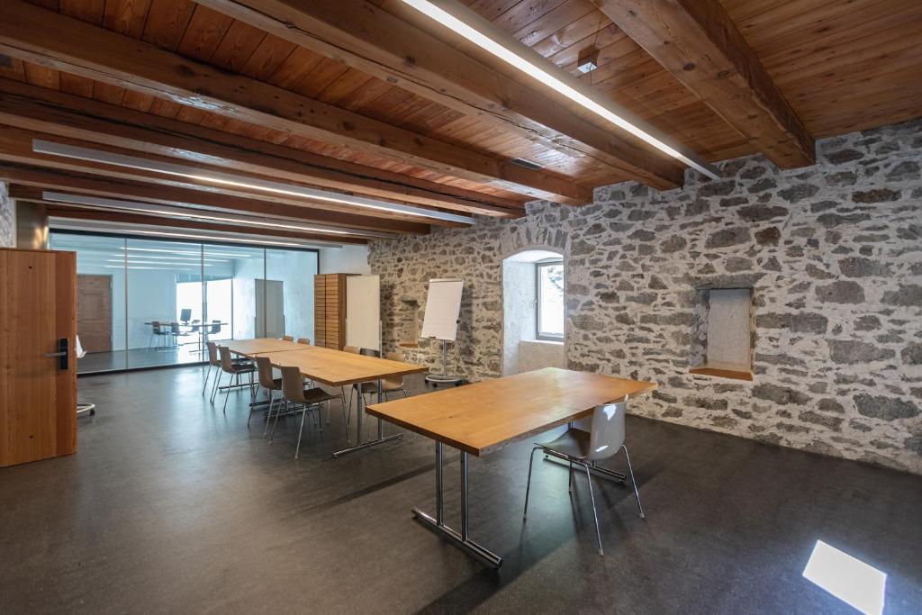 a row of tables in a room with stone walls at Hotel Restaurant Stockalperturm in Ruden