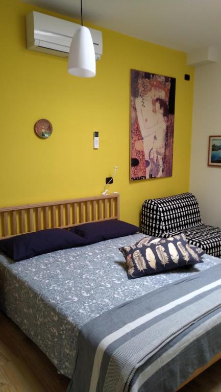 1 dormitorio con cama y pared amarilla en Alla corte della suocera bilo, en Bari