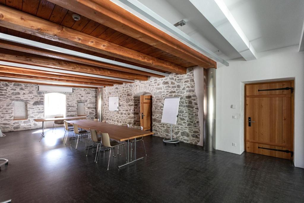 a large room with a wooden table and chairs at Hotel Restaurant Stockalperturm in Ruden