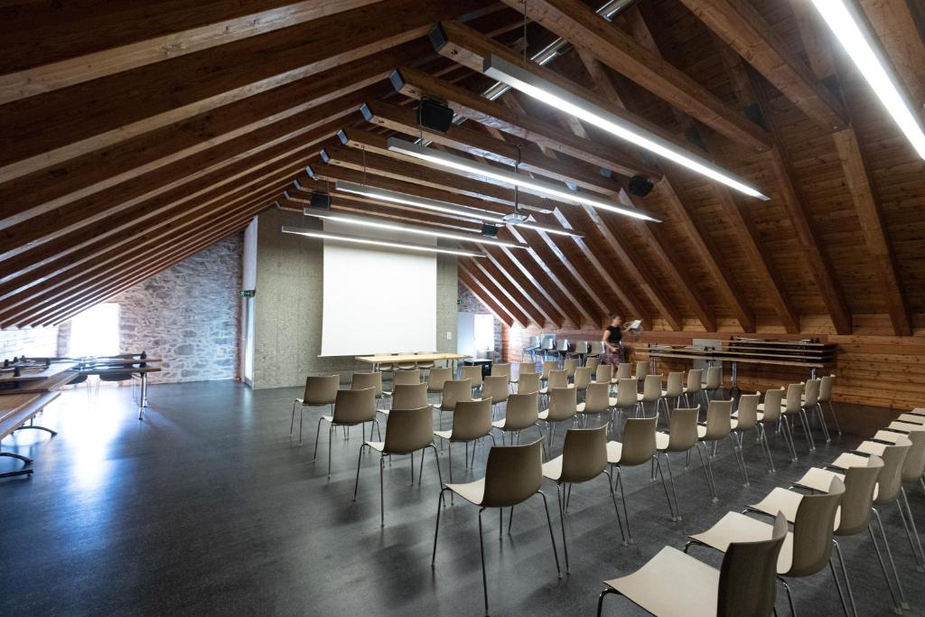 a room with rows of chairs and a white screen at Hotel Restaurant Stockalperturm in Ruden