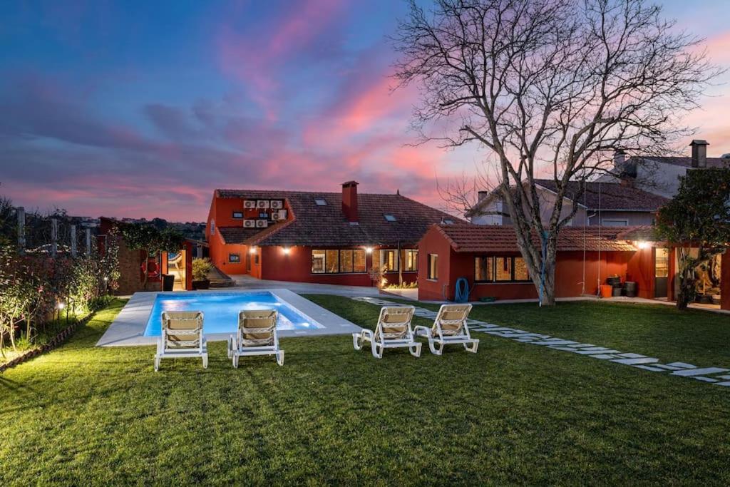 a yard with chairs and a swimming pool at Casa dos Mortágua in Fermelã