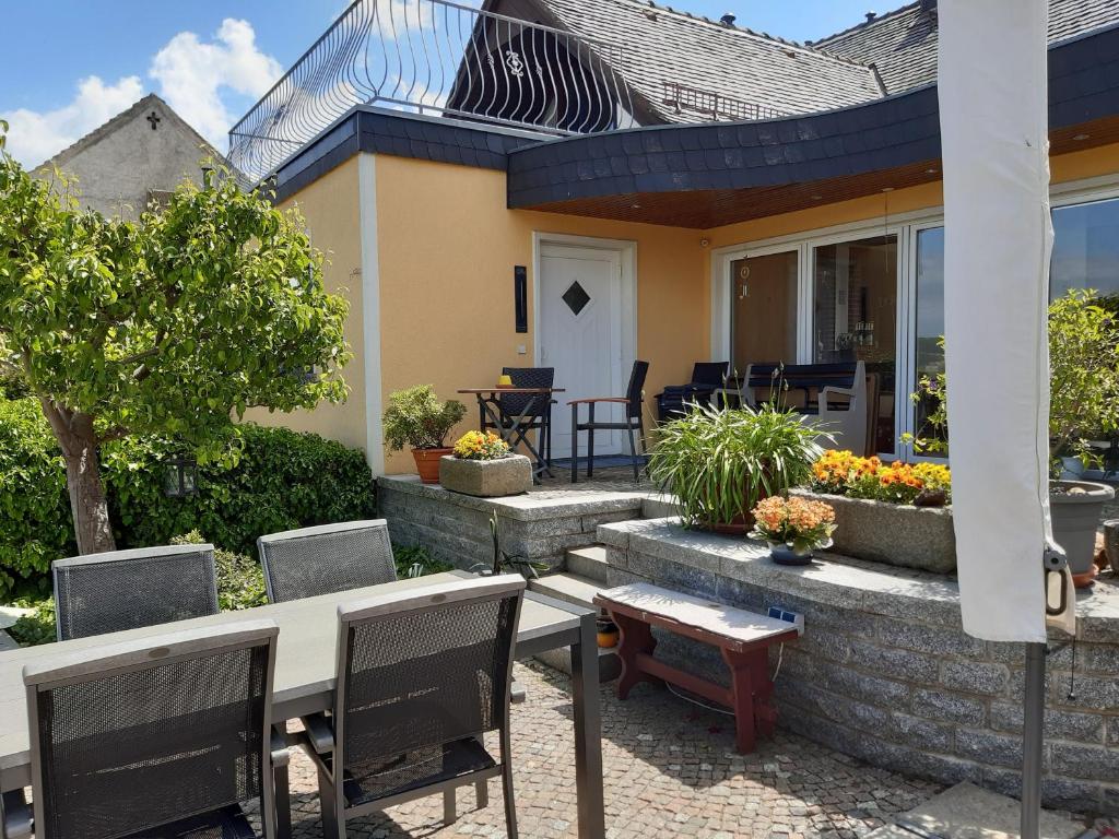 eine Terrasse mit einem Tisch und Stühlen vor einem Haus in der Unterkunft NEU Apartment Hanka in Crostwitz