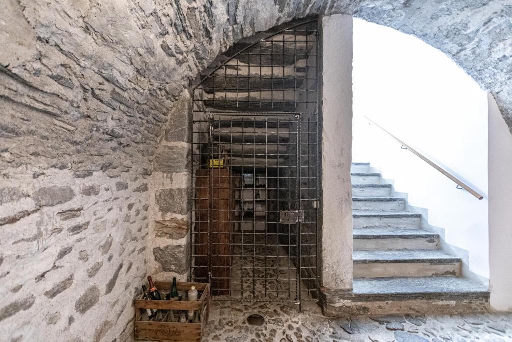 a staircase in a stone wall with a metal gate at Hotel Restaurant Stockalperturm in Ruden