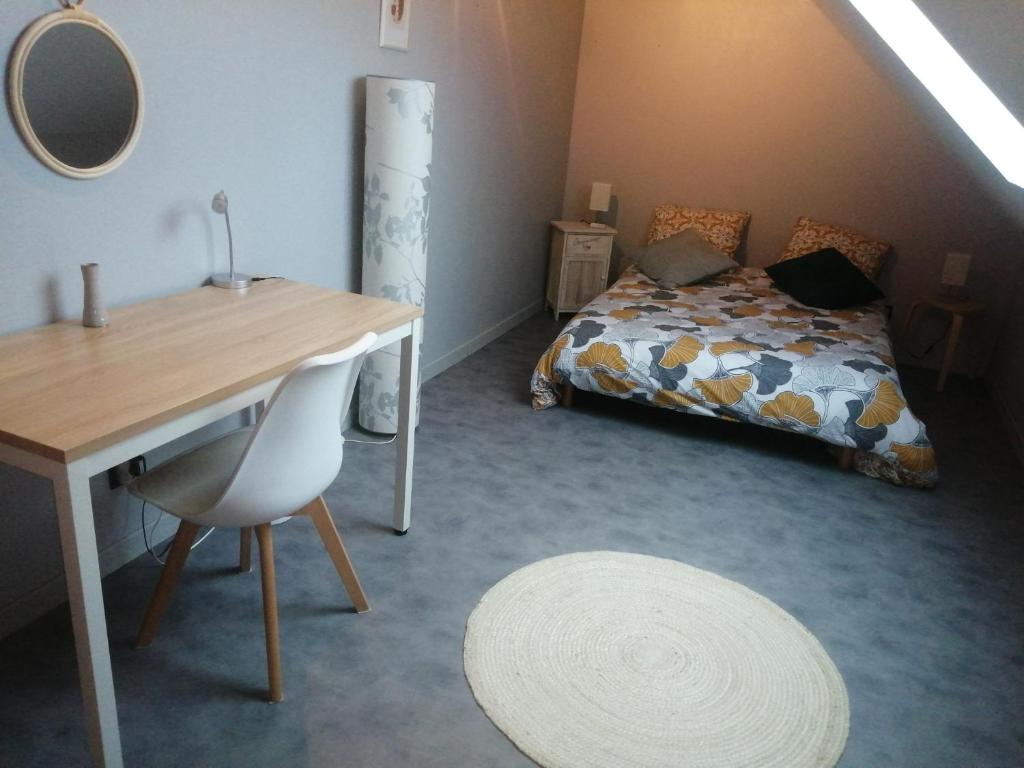 Zimmer mit einem Schreibtisch, einem Bett und einem Tisch in der Unterkunft la maison d'Elise in Dollon