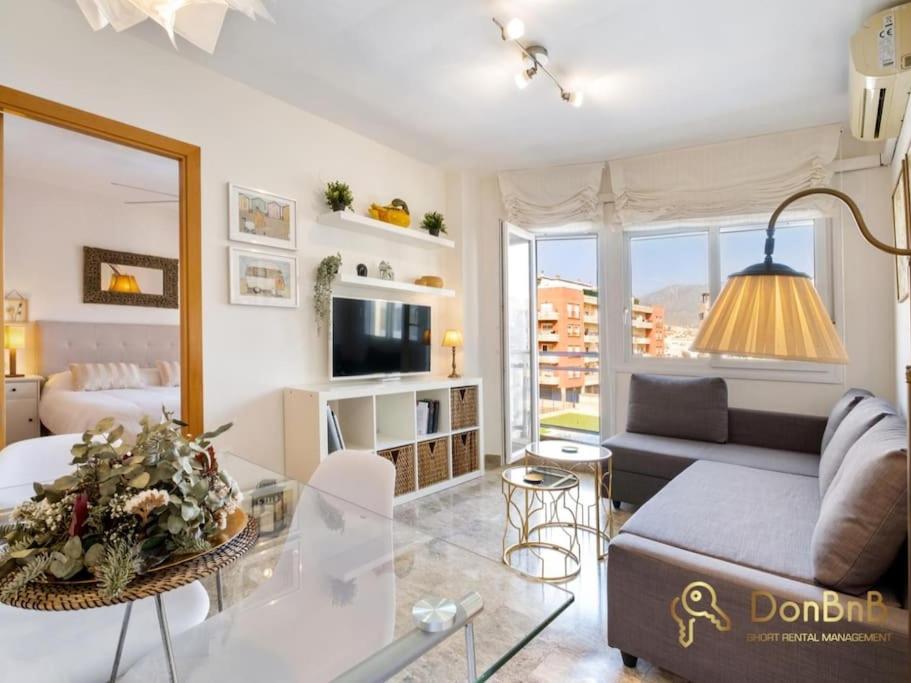 a living room with a couch and a glass table at Apartment with pool and private parking near Aqua Mijas in Fuengirola