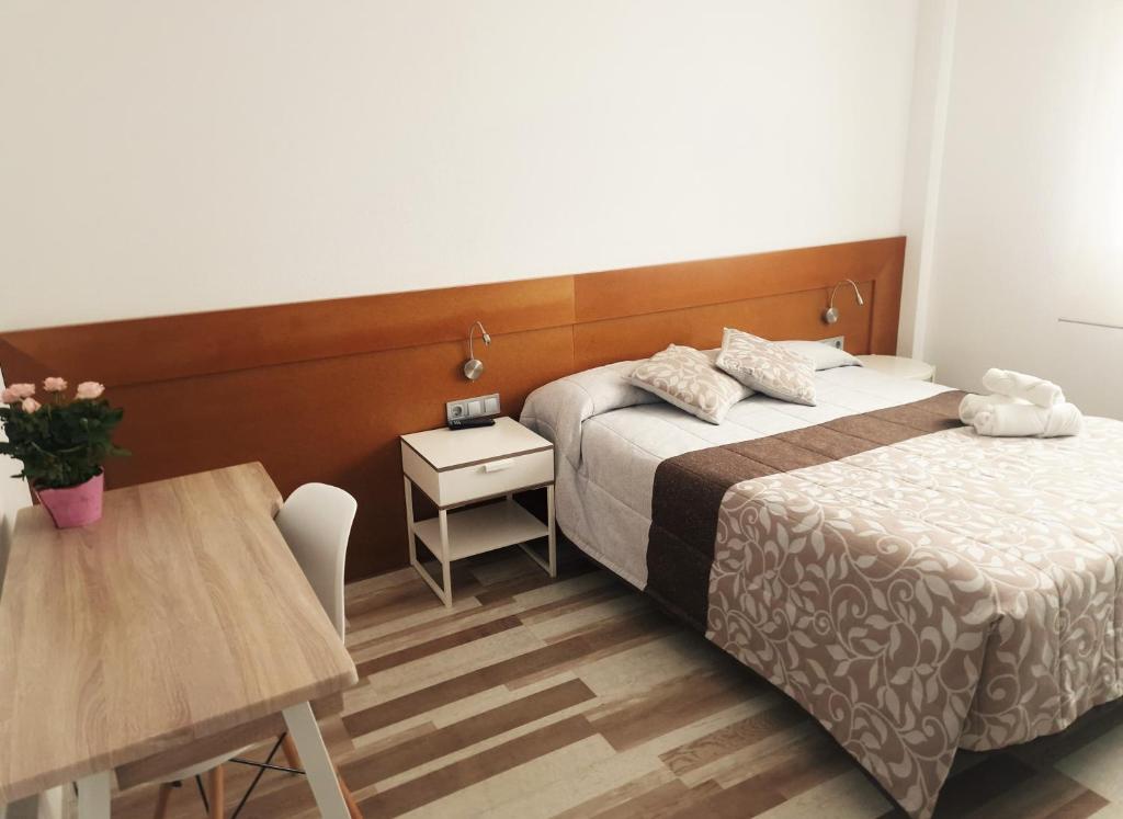 pokój hotelowy z 2 łóżkami i stołem w obiekcie Hotel Area Serrano w mieście Buniel