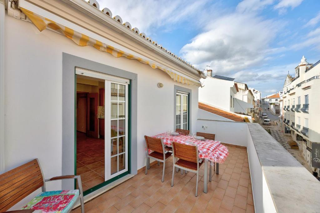 een patio met een tafel en stoelen op een balkon bij Tourismer Centro 31 in Lagos