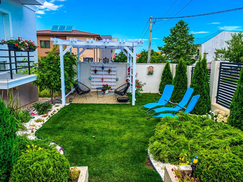 a backyard with chairs and a white pergola at House Lake in Techirghiol