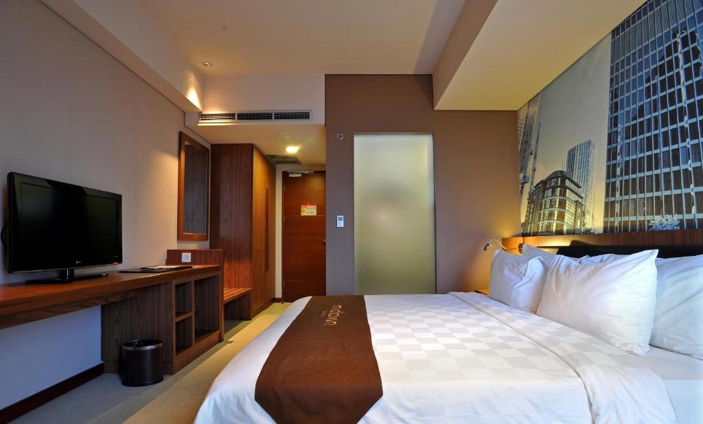 Postel nebo postele na pokoji v ubytování Midtown Hotel Surabaya