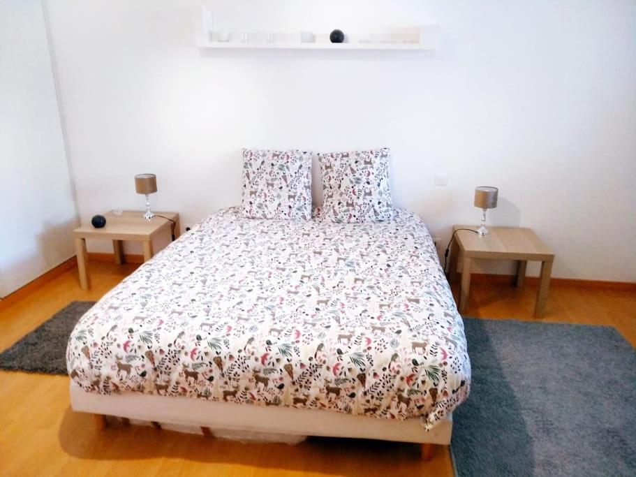 a bedroom with a large bed with two tables at L'Embrun de la Baie de Somme in Saint-Valery-sur-Somme