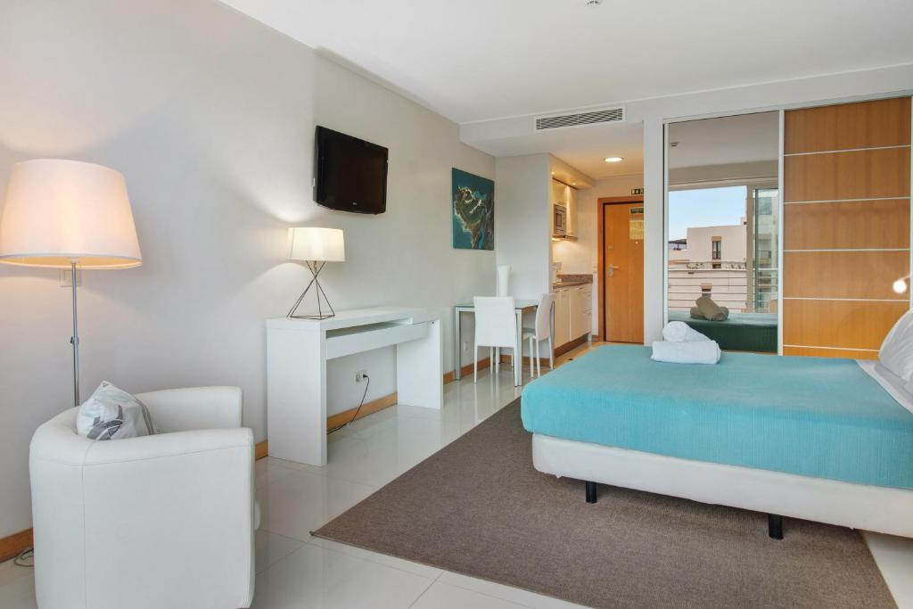 een slaapkamer met een bed en een stoel in een kamer bij Dfm Happy Days E - Funchal in Funchal