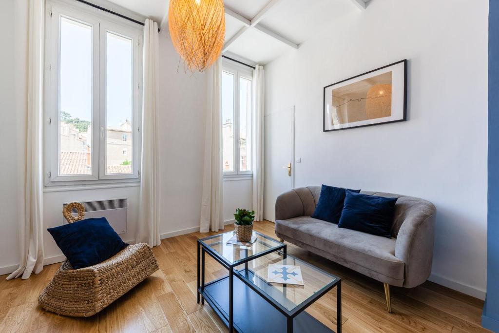 ein Wohnzimmer mit einem Sofa und einem Tisch in der Unterkunft La Bonne Mère-Vue Notre-Dame de La Garde in Marseille
